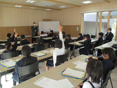 説明を受けて手を挙げる生徒たちの写真