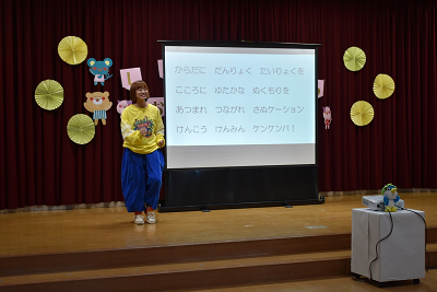 スクリーンの横に立って話している女性の写真