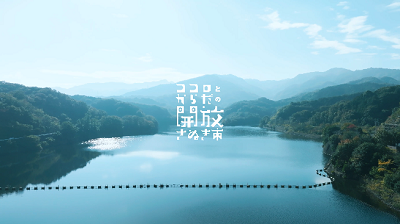 中心に「ココロとからだの開放 さぬき市」と書かれた山と湖の風景写真