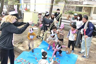 地面に散らばったお菓子を拾う子供たちの写真