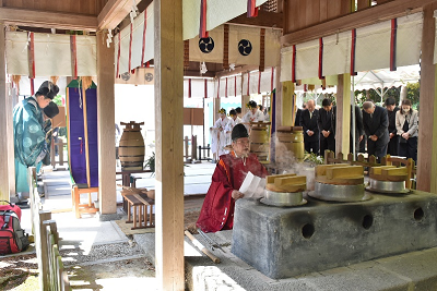 竈の前で男性が祝詞を読み上げている写真