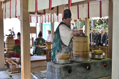 男性が甑に手を伸ばしている写真