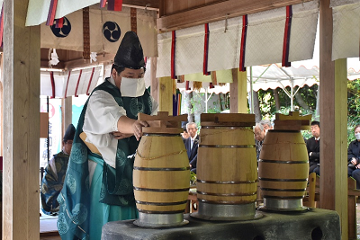 男性が甑の蓋に手をかけている写真