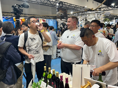 小さい紙コップでワインの試飲をする男性の写真