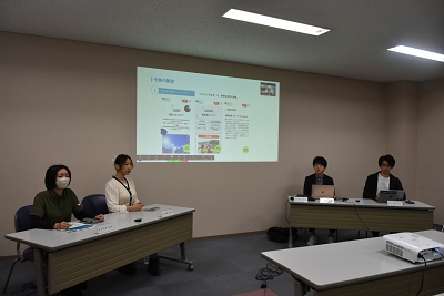 スクリーンの内容を使って説明をしている人たちの写真