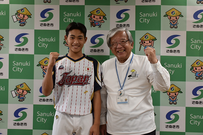 ユニフォームを着た人と男性がガッツポーズをとっている写真