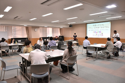 グループで机に座って話を聞く参加者の写真