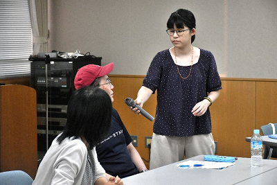 マイクを向けられて答える男性の写真