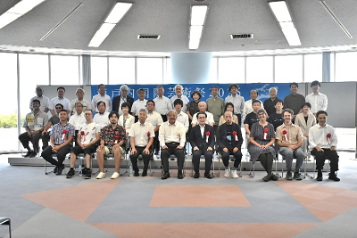 大勢の人が座って3列に並んでいる写真