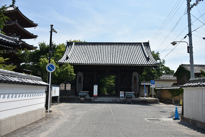 塔が近くにある瓦屋根が付いた門の写真