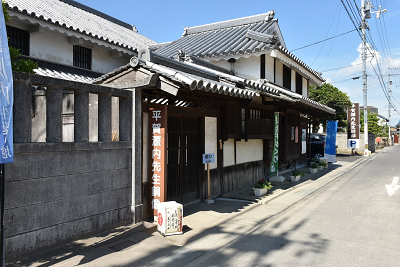 「平賀源内先生銅像」と書かれた看板がある瓦屋根の建物の写真