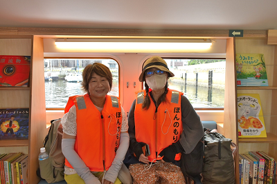 オレンジのライフジャケットを着た女性2人の写真