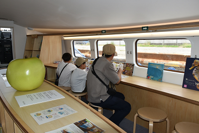 船内で椅子に座って本を読む親子の写真