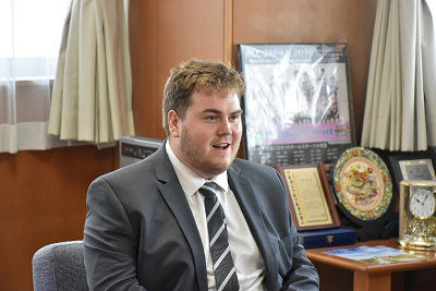 スーツを着た金髪の男性が話している写真