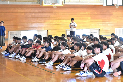 体育座りで話を聞く生徒達の写真