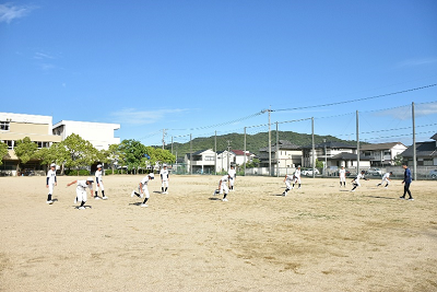 校庭で準備運動をする野球部員の写真
