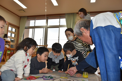 色塗り体験をする園児たちと男性の写真