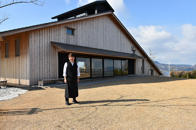 大串活性化施設時の納屋の前に立つ男性の写真