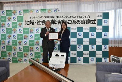 女性と男性が感謝状を持っている写真