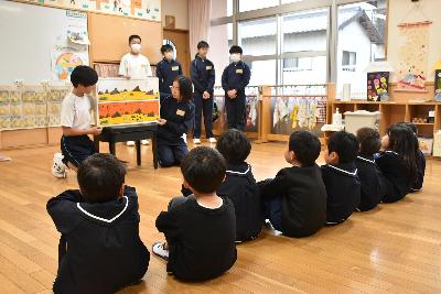 園児に絵本を読み聞かせる2人の生徒