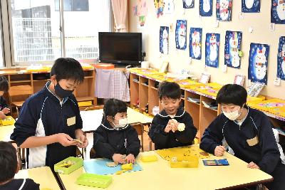 粘土で工作する4人の生徒と園児
