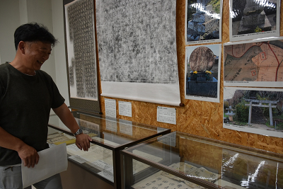 ショーケースに手を置き、展示物の説明をする男性