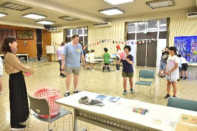 ミッションの一環で、椅子の上のカゴにボールを投げ入れる女の子