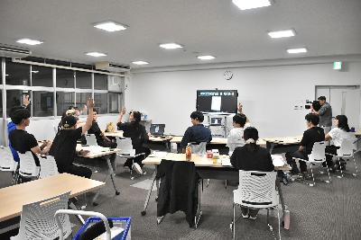 話し合いの中で席に座った複数の実行委員が挙手する様子
