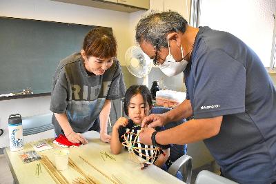 講師に教わりながらボールを作る親子2名