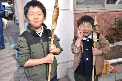 竹パンづくりでつくったパンを食べる2名の子どもたち