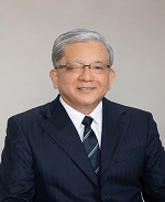 眼鏡をかけたスーツ姿の男性が微笑んでいる写真