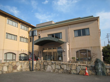 くの字に建てられて肌色をした建物の写真