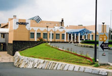 道案内の看板とその奥に橙色の外装の建物が建っている写真