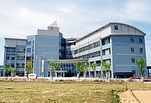 広場の奥に建つ水色の壁の建物の写真