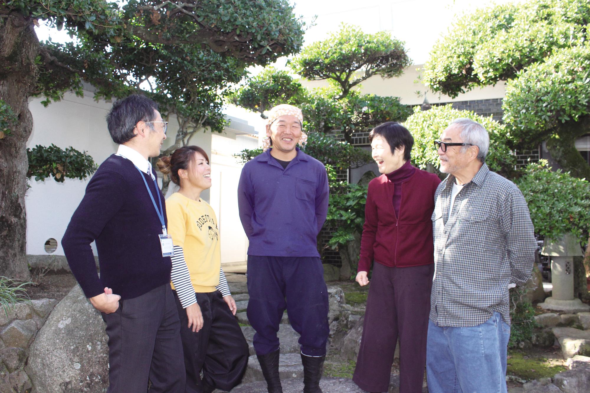 お客様の庭先で談笑する夫妻