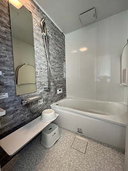 ゆったりと足を伸ばして入れるサイズの浴槽と広い洗い場があるバスルームの写真