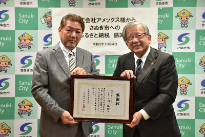 令和5年10月4日に行われた株式会社アメックスへの感謝状贈呈式で市長と代表者が感謝状を持って並んでいる記念写真