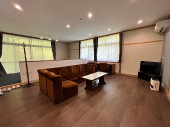 フローリングに大きなソファーが置かれたリビングの写真