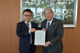 令和5年度の提言書を市長と男性が持って並んでいる写真